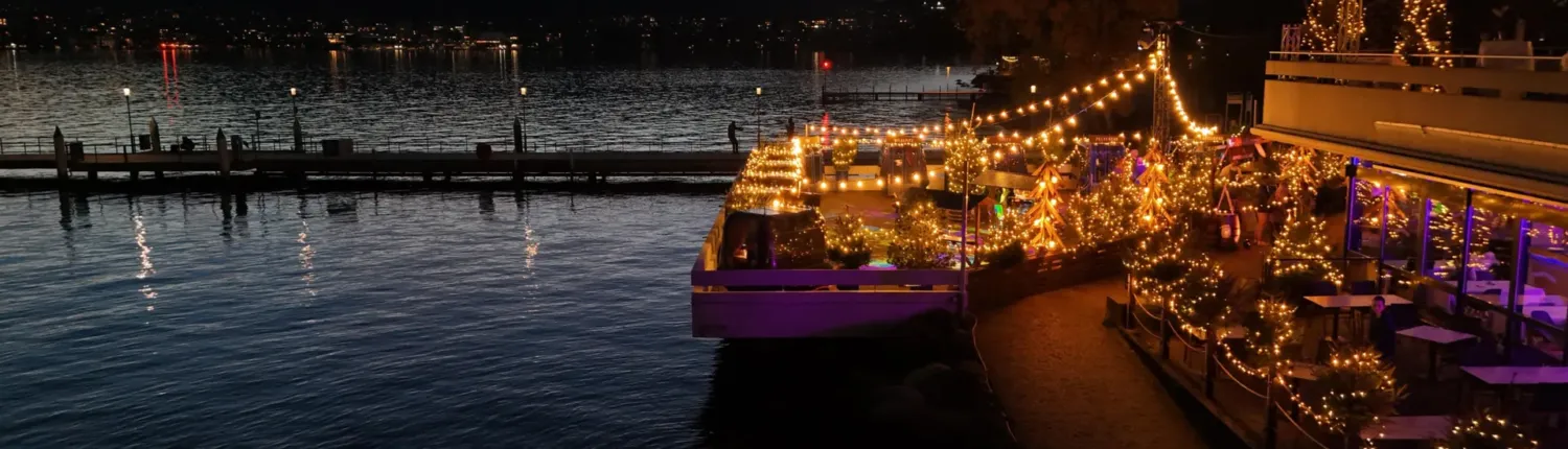 Gondola Island bei Nacht: Seeterrasse mit Lichterketten und Gondeln direkt am Zürichsee